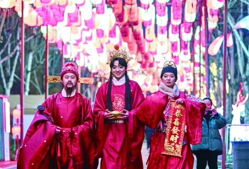 “2026年重庆市新春灯会—‘禧欢霓’园博园大型水上灯会”近日启动,图为景区工作人员在灯会现场送祝福。新华社发